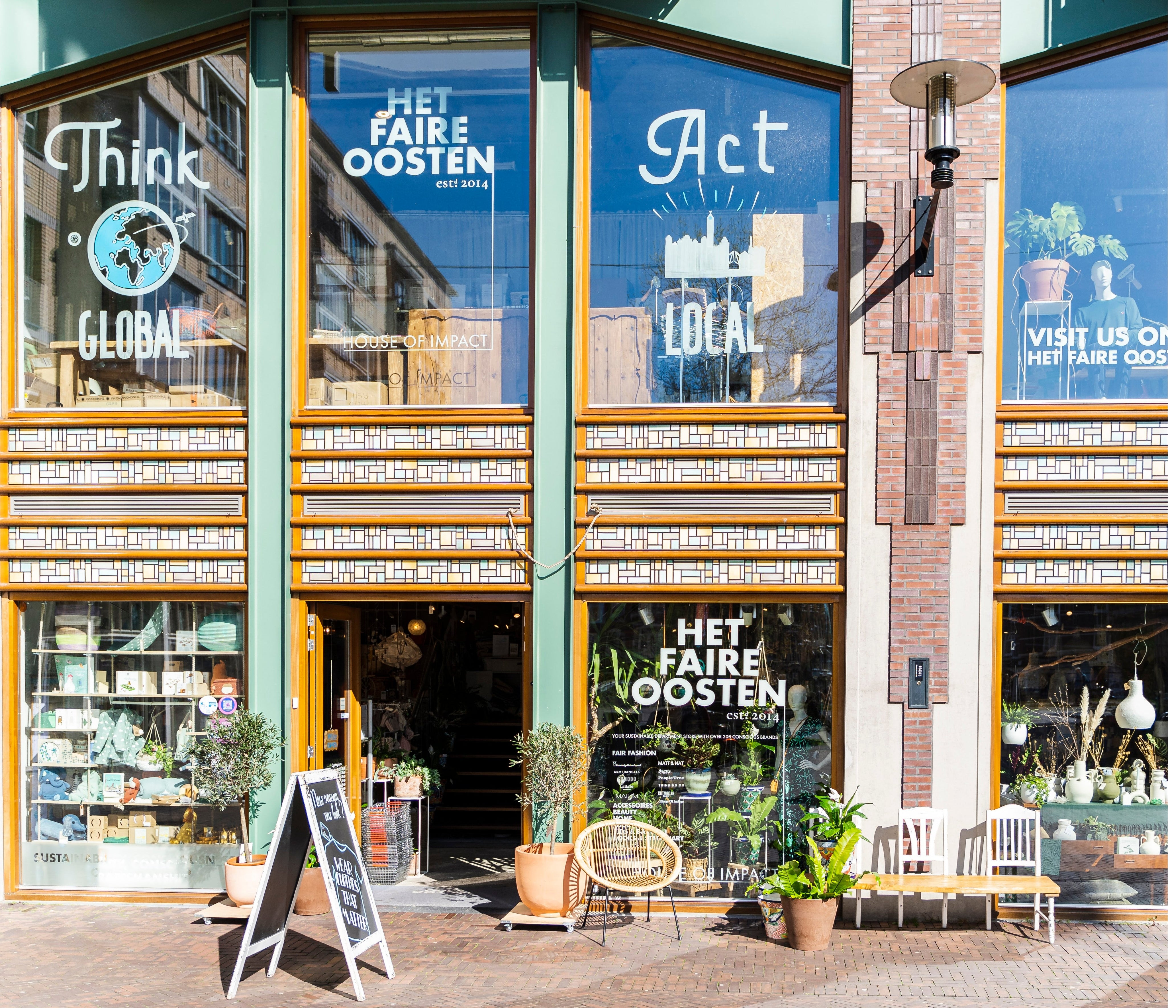 Storefront with large glass windows displaying 'Het Faire Oosten' branding and interior.